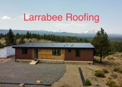 Larrabee Roofing on a modern home surrounded by trees and mountains.