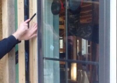 Person inspecting window frame for installation, highlighting construction details.