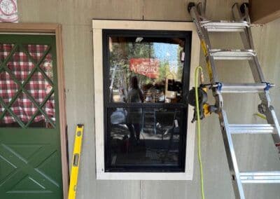 New Milgard window installation with ladder and tools on a home exterior.
